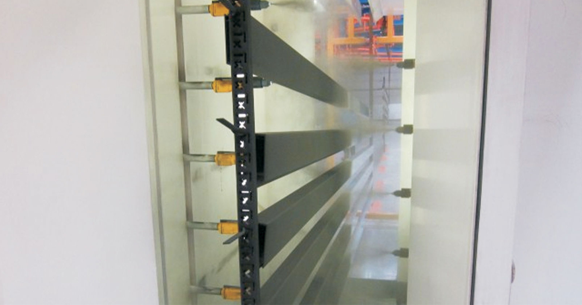 Aluminium profiles being electrostatically powder coated in a spray booth